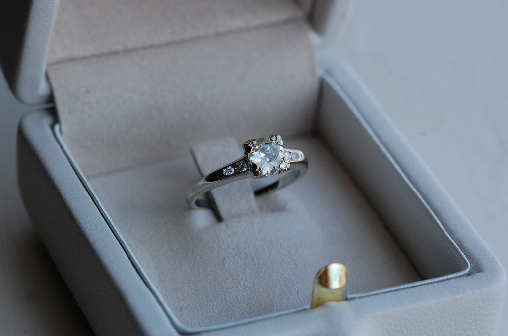 Close up of diamond ring being displayed in a gray colored ring box.