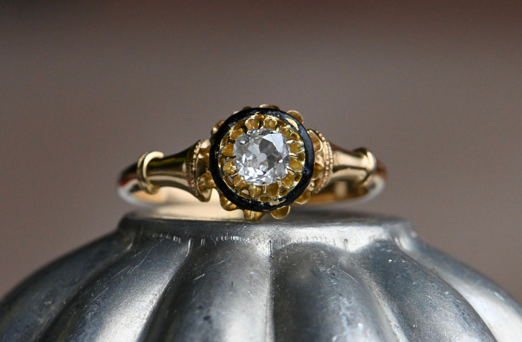 An 18K Victorian solitaire engagement ring with tiers of details and a VS/E-F Old Mine Cut diamond. Victorian engagement rings all share some common attributes: Old cut diamonds, usually set as singletons (sometimes as trios); multi-prong settings in high-karat yellow gold; buttercup heads and trumpet-style shoulders