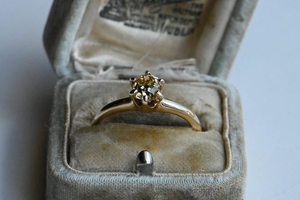 A fancy yellow Old Mine Cut diamond tucked in an early 20th century solitaire mounting. We found this mounting and diamond separately and decided to play matchmaker! The classic six-pronged mounting is marked for Dattlebaum & Friedman, NY, NY, a firm that specialized in rings beginning in 1904.