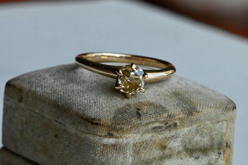 A fancy yellow Old Mine Cut diamond tucked in an early 20th century solitaire mounting. We found this mounting and diamond separately and decided to play matchmaker! The classic six-pronged mounting is marked for Dattlebaum & Friedman, NY, NY, a firm that specialized in rings beginning in 1904.
